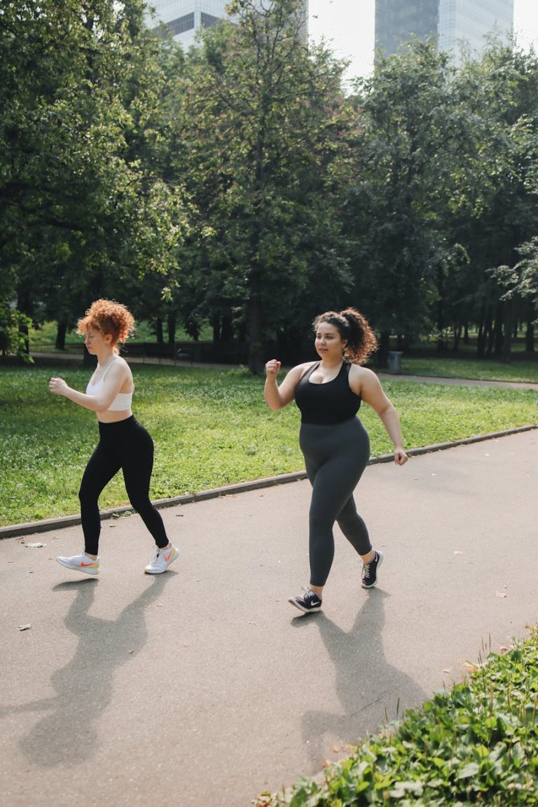 a pair of women in active wear brisk walking on walkway